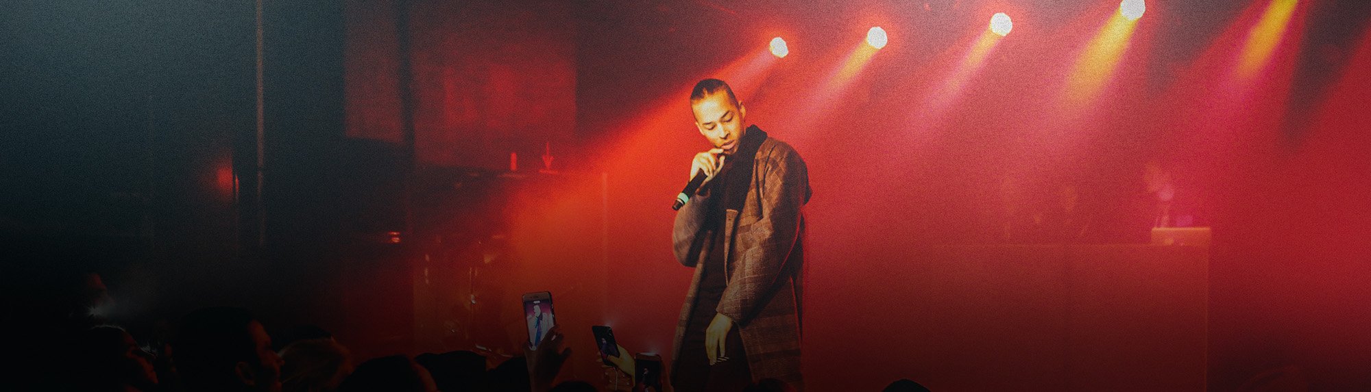 Person on stage performing into a microphone