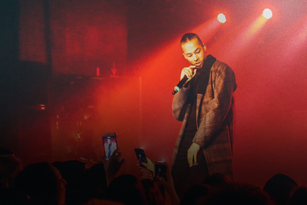 Person on stage performing into a microphone