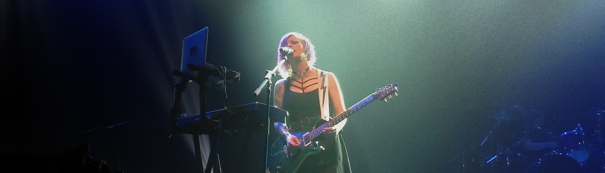 Woman performing with a guitar on stage