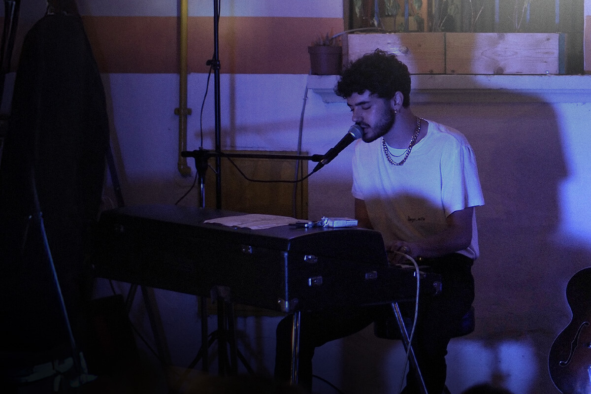 Man singing into a microphone and playing piano