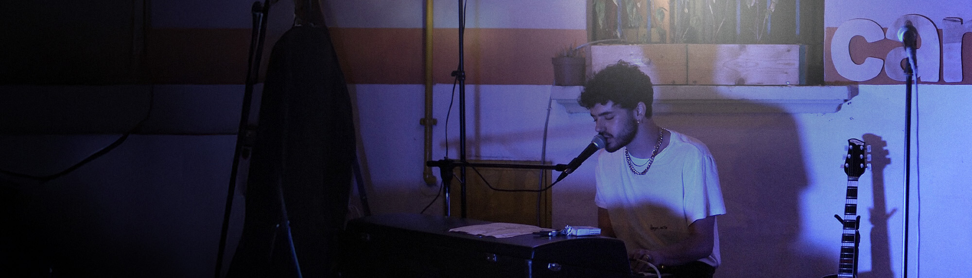 Man singing into a microphone and playing piano