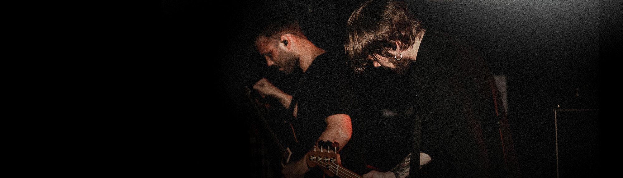 Two musicians on stage tuning their instruments