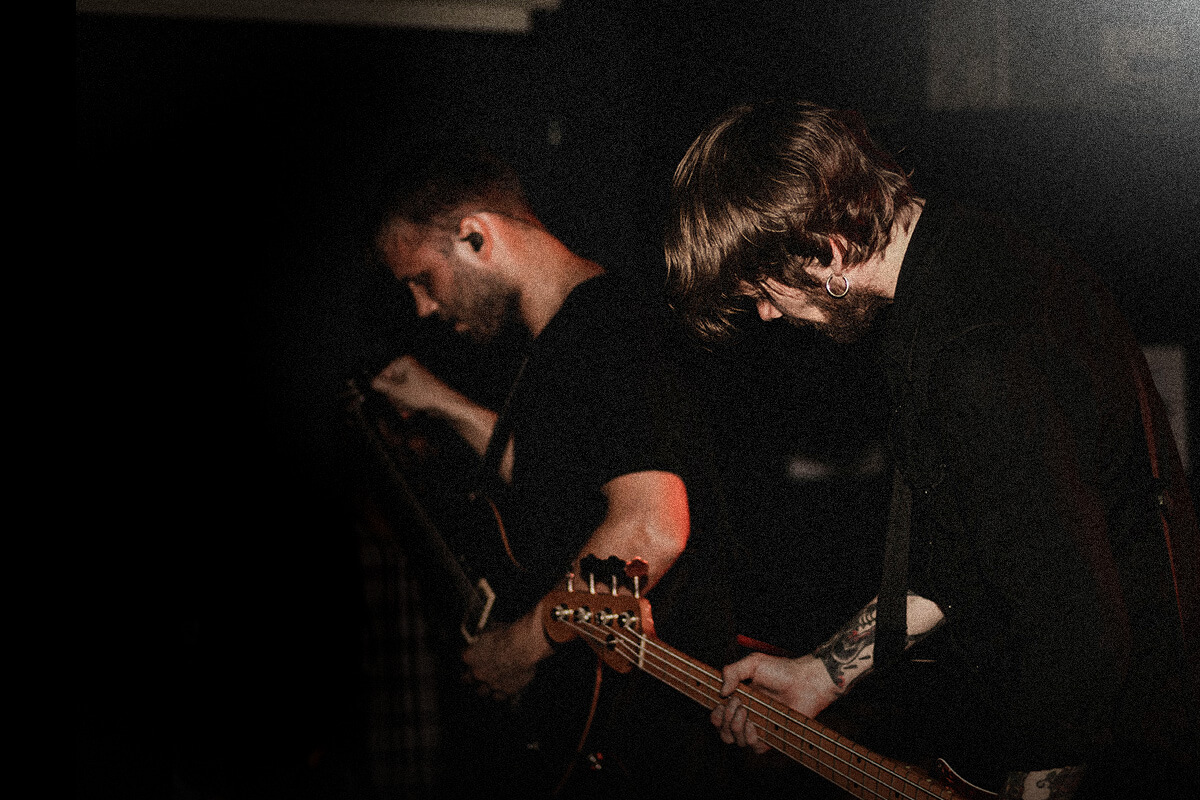 Two musicians on stage tuning their instruments