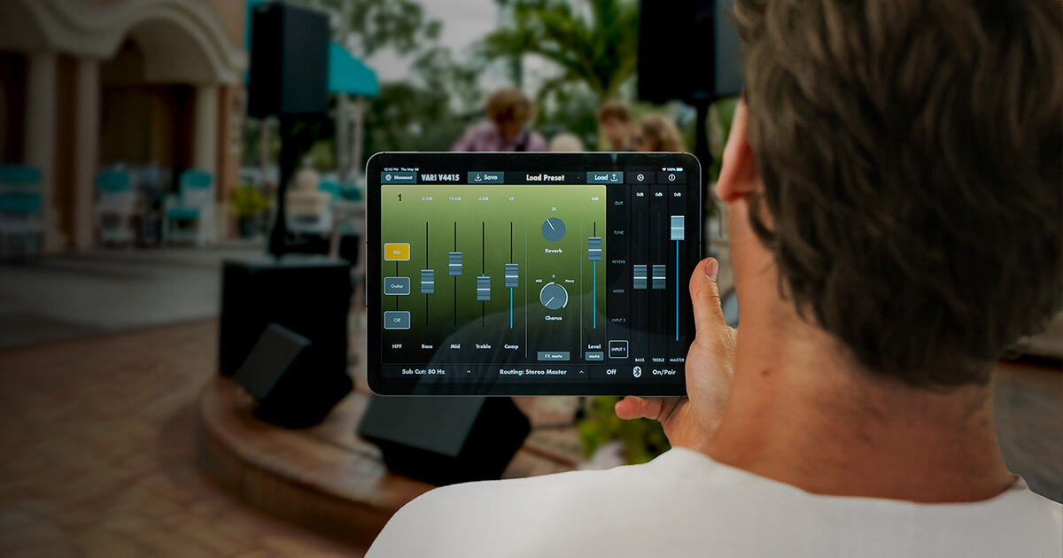 Man holding an ipad showing the Harbinger Vari App mixer controls