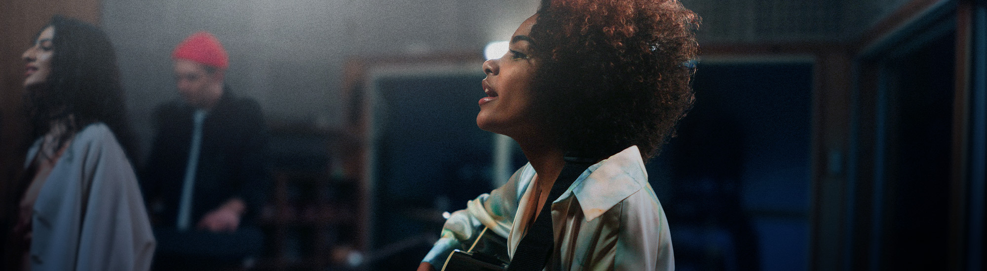 A woman recording singing and playing guitar